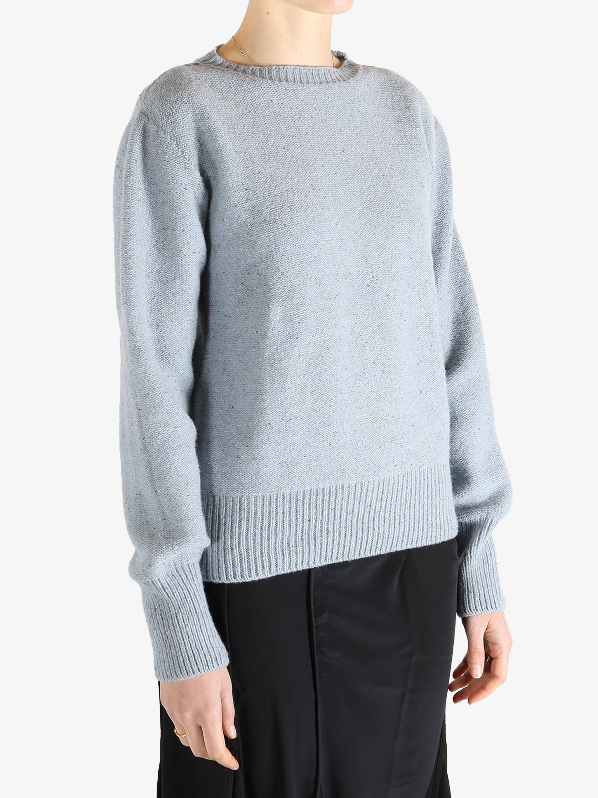Blue sweater worn by a person, showing the sweater's fit