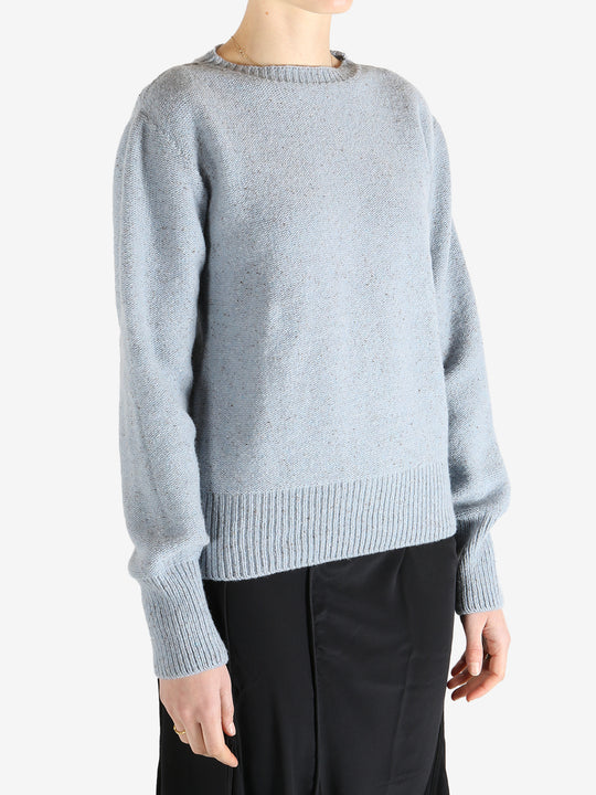Blue sweater worn by a person, showing the sweater's fit