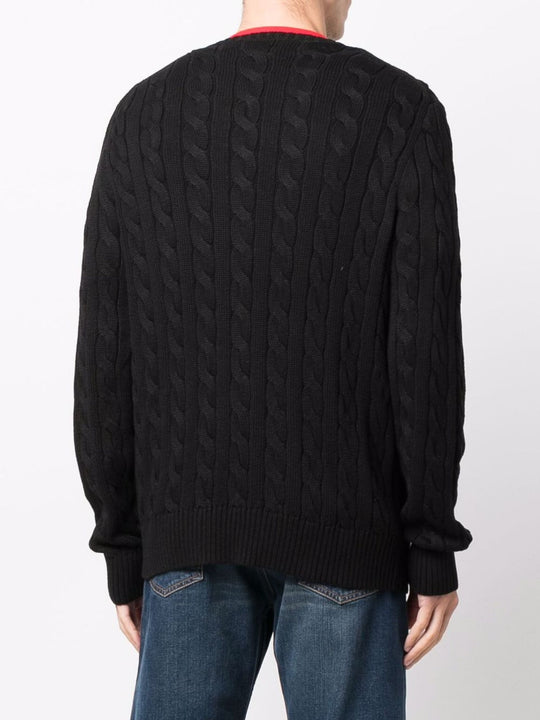 Black sweater worn by a person, showing the sweater's fit