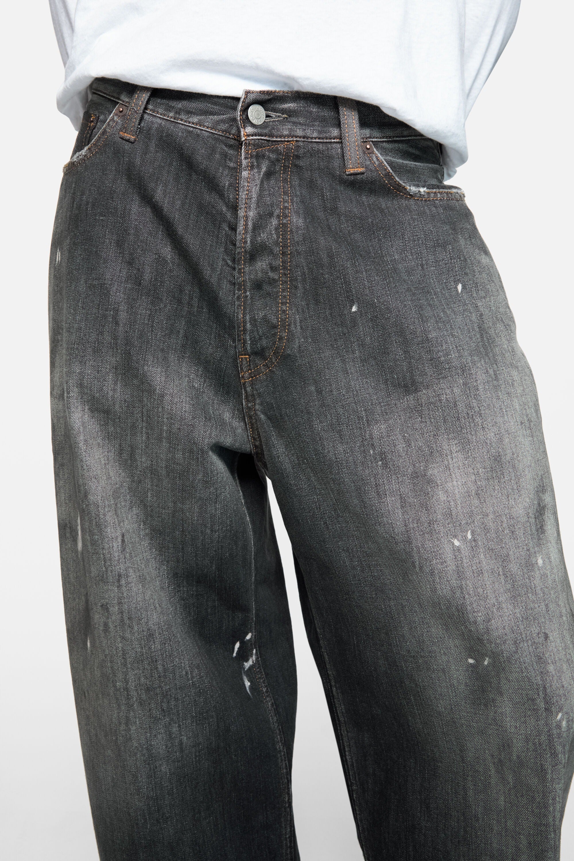 Black jeans worn by a person, showing the jeans fit
