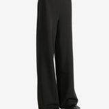 Black pants worn by a person,showing the pants' fit