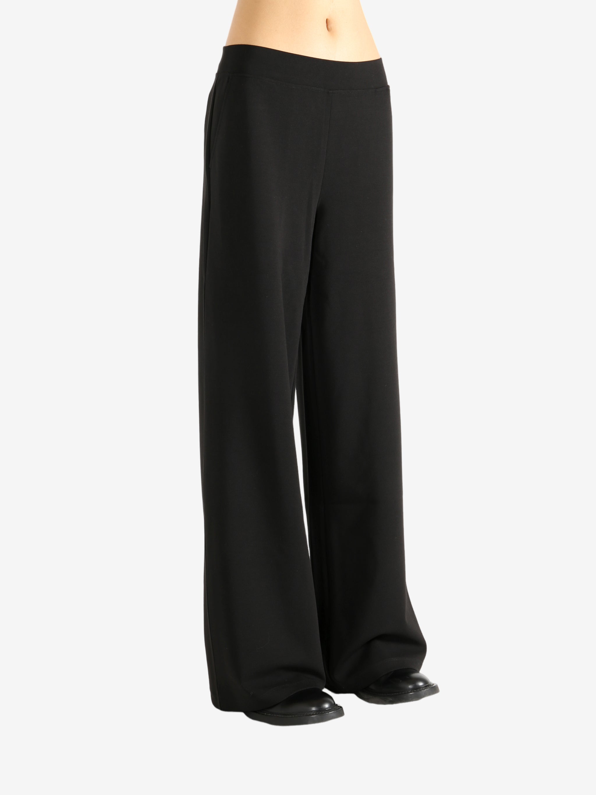 Black pants worn by a person,showing the pants' fit