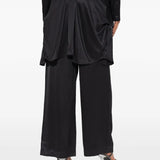 Black pants worn by a person, showing the pants' fit