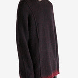 Black knitwear worn by a person, showing the knitwear's fit