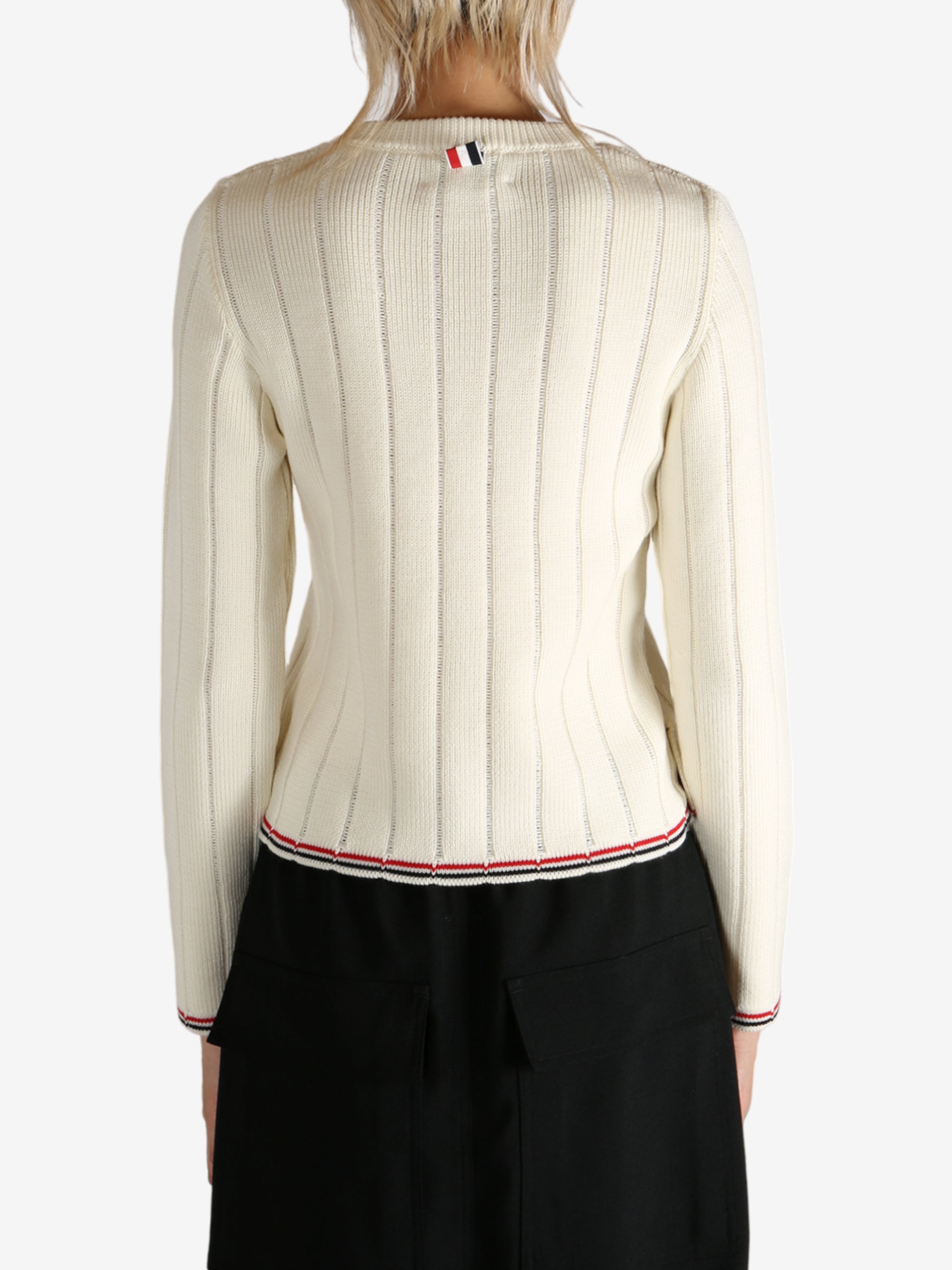 White knitwear worn by a person, showing the knitwear's fit