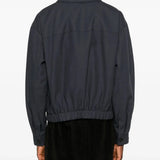 Black coat worn by a person, showing the jacket's fit