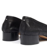 Close up of the black heels, showing texture of the leather fabric