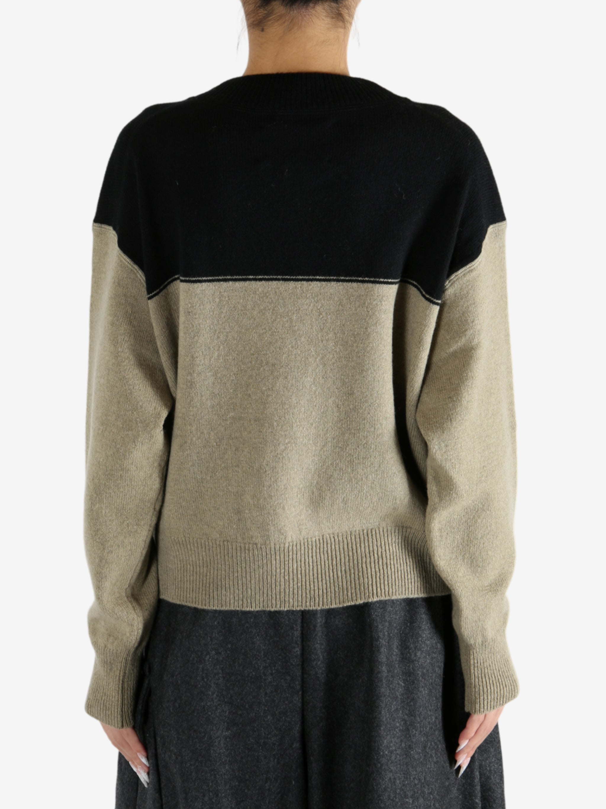 Black knitwear worn by a person, showing the knitwear fit