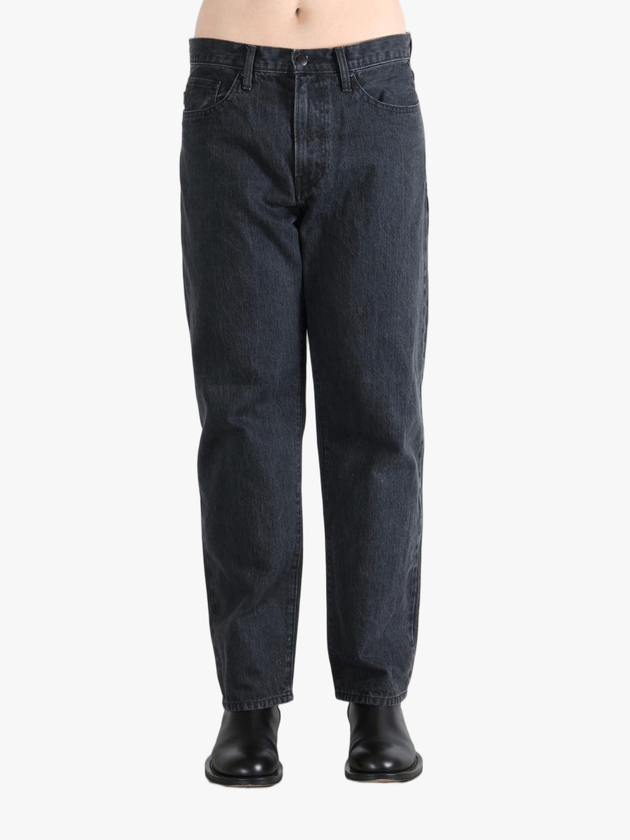 Black jeans worn by a person, showing the jeans fit