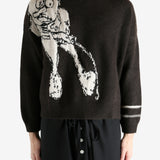 Black sweater worn by a person, showing the sweater's fit