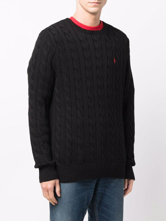 Black sweater worn by a person, showing the sweater's fit