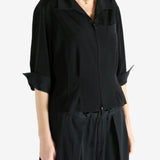 Black shirts worn by a person, showing the shirts fit