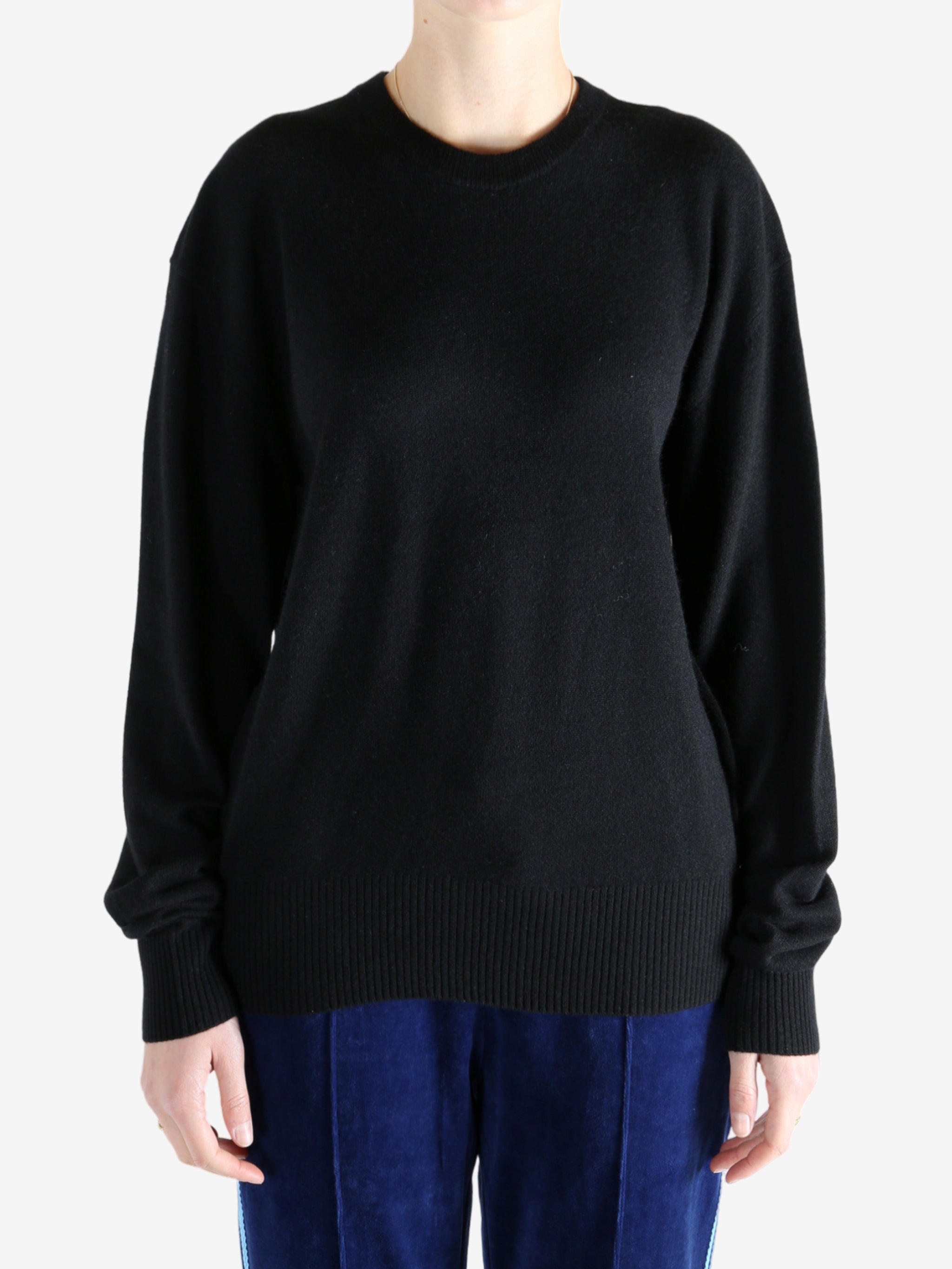 Black knitwear, worn by a person, showing the knitwear's fit