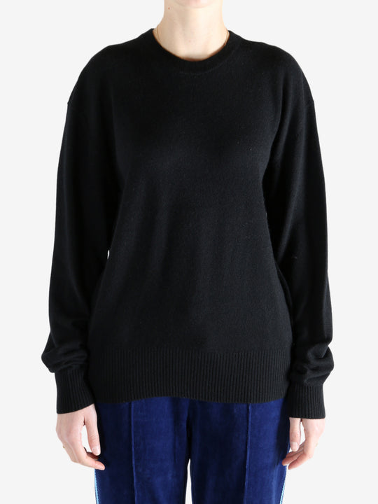 Black knitwear, worn by a person, showing the knitwear's fit