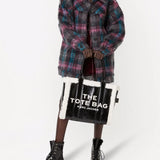 Black bag carried by a person, showing the bag's fit