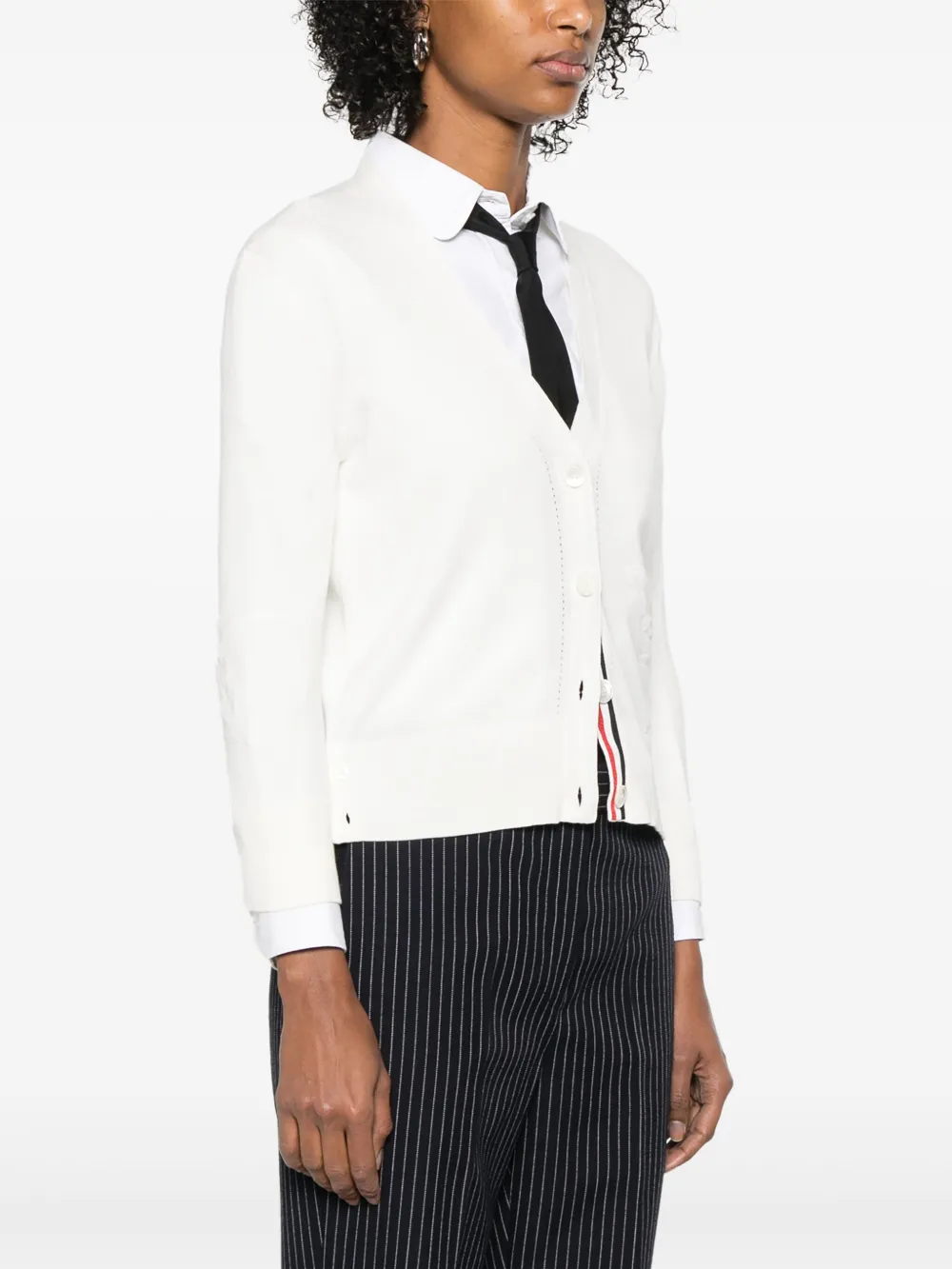 Whtie knitwear worn by a person, showing the cotton fit