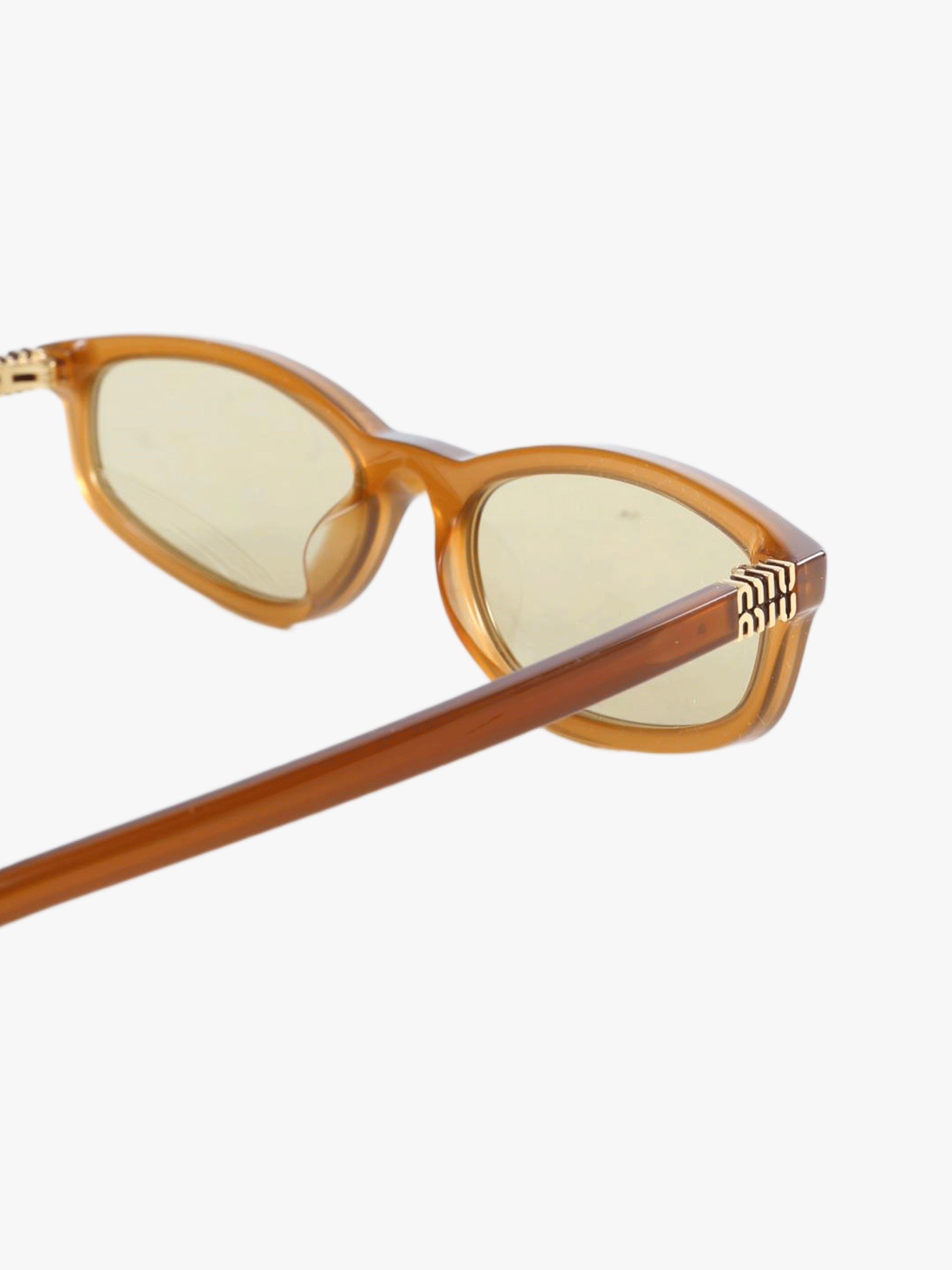 Close up of the yellow sunglasses, showing texture of the acetate fabric