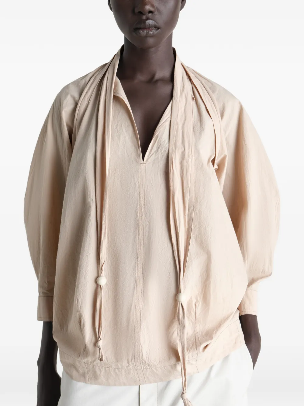Tan top worn by a person, showing the top's fit