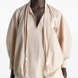 Tan top worn by a person, showing the top's fit