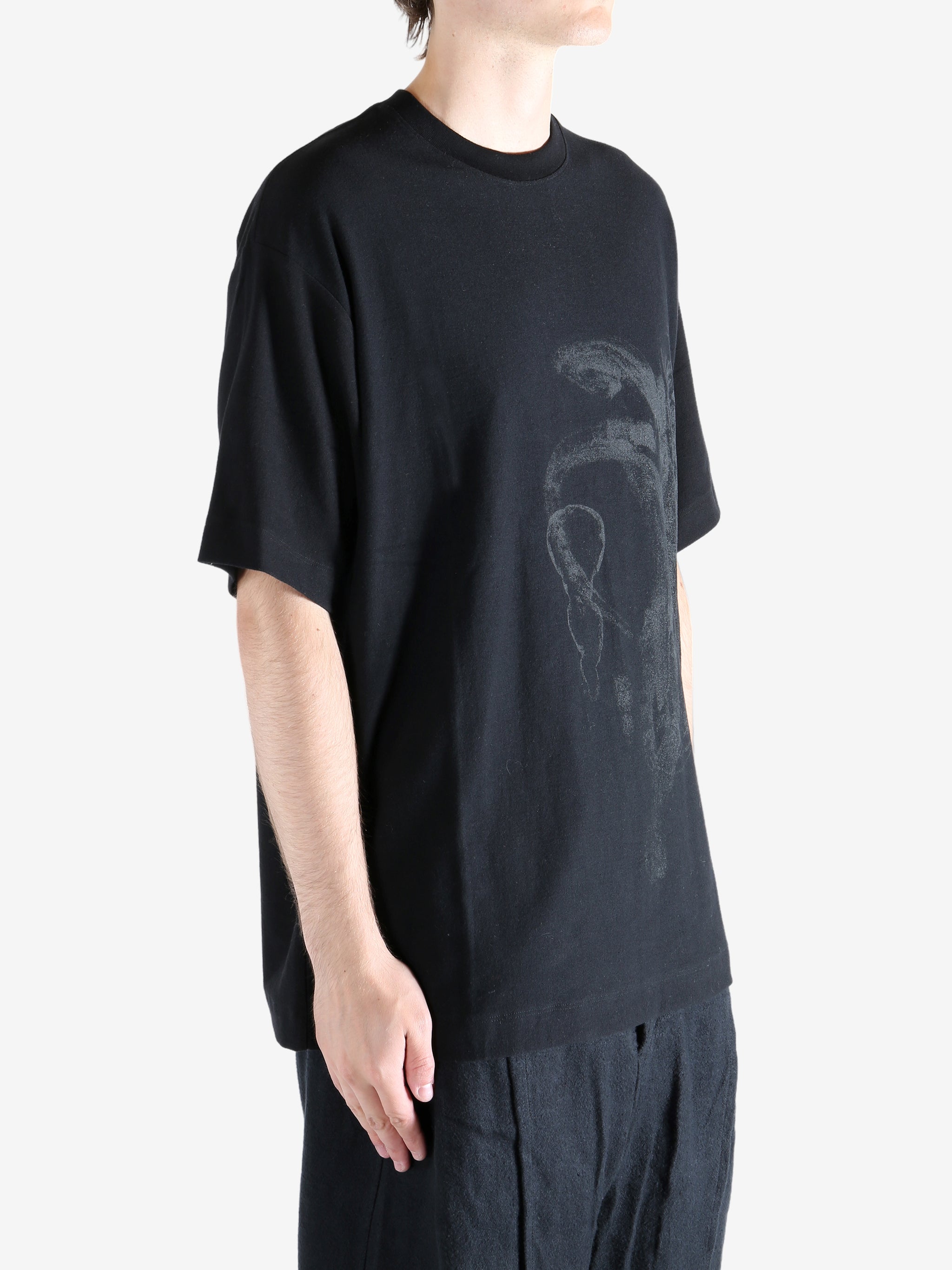 Black t-shirts worn by a person, showing the t-shirts' fit