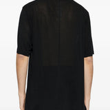 Black t-shirts worn by a person, showing the t-shirts fit