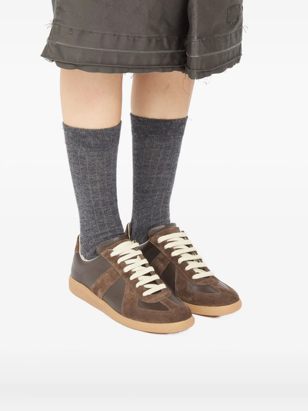 Brown sneakers worn by a person, showing the sneakers's fit