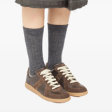 Brown sneakers worn by a person, showing the sneakers's fit