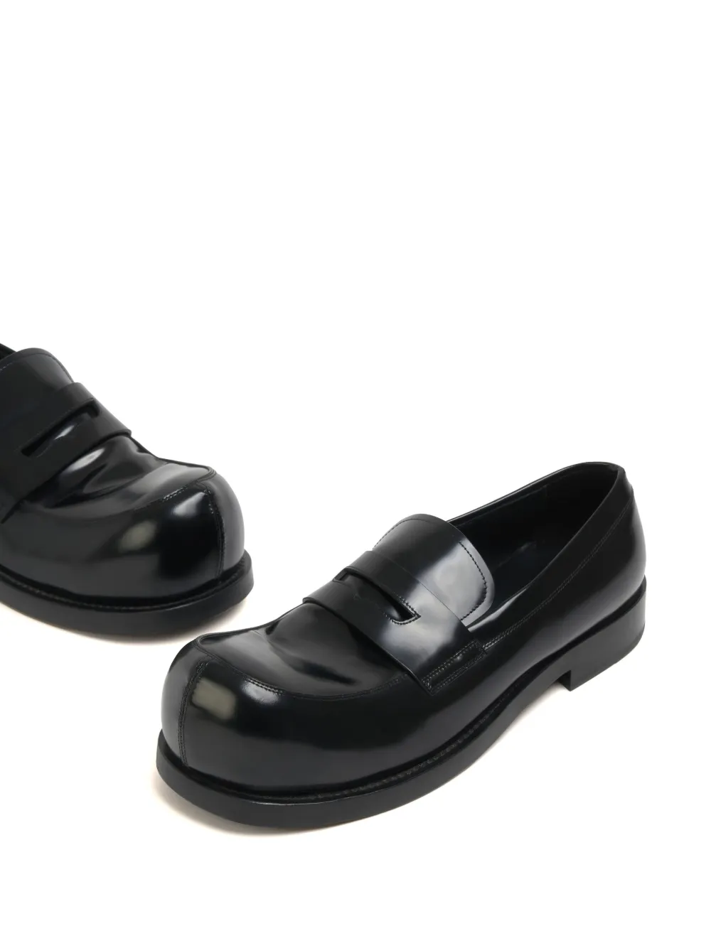 Close up of the black loafer, showing texture of the leather fabric