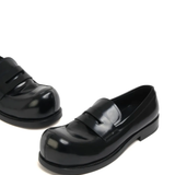 Close up of the black loafer, showing texture of the leather fabric