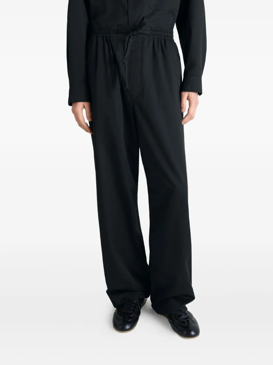 black pants worn by a person, showing the pants fit