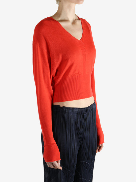 Red long-sleeve top worn by a person, showing the top fit