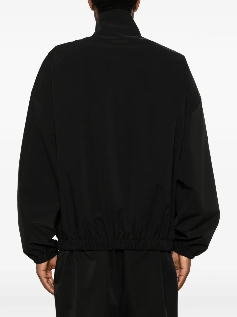 Black coats worn by a person, showing the coats fit