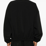 Black coats worn by a person, showing the coats fit