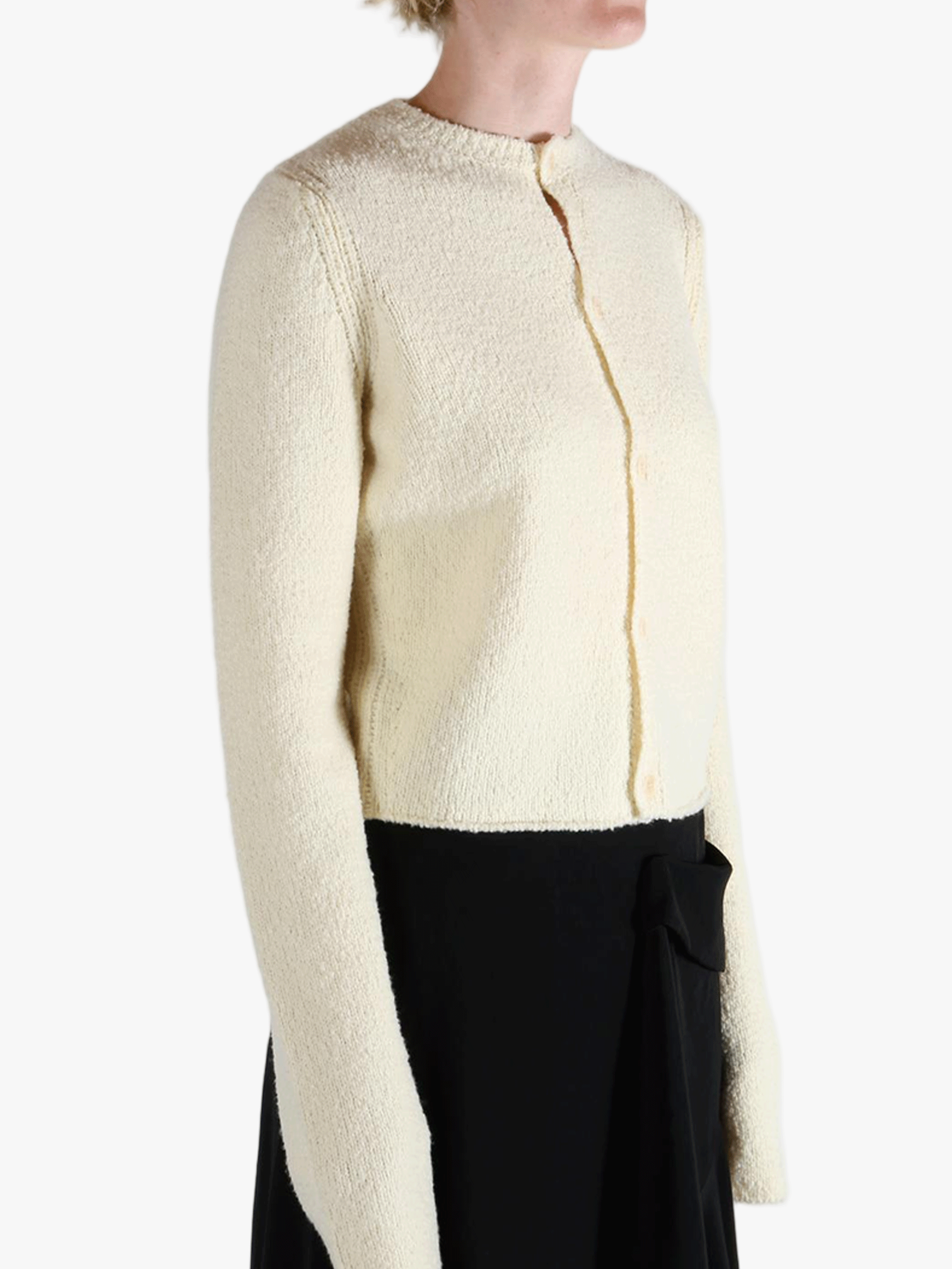 White cardigan worn by a person, showing the cardigan's fit