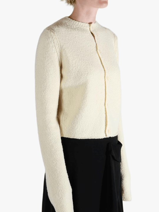 White cardigan worn by a person, showing the cardigan's fit