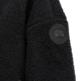 Close up of black jackets, showing texture of the wool and polyester fabric
