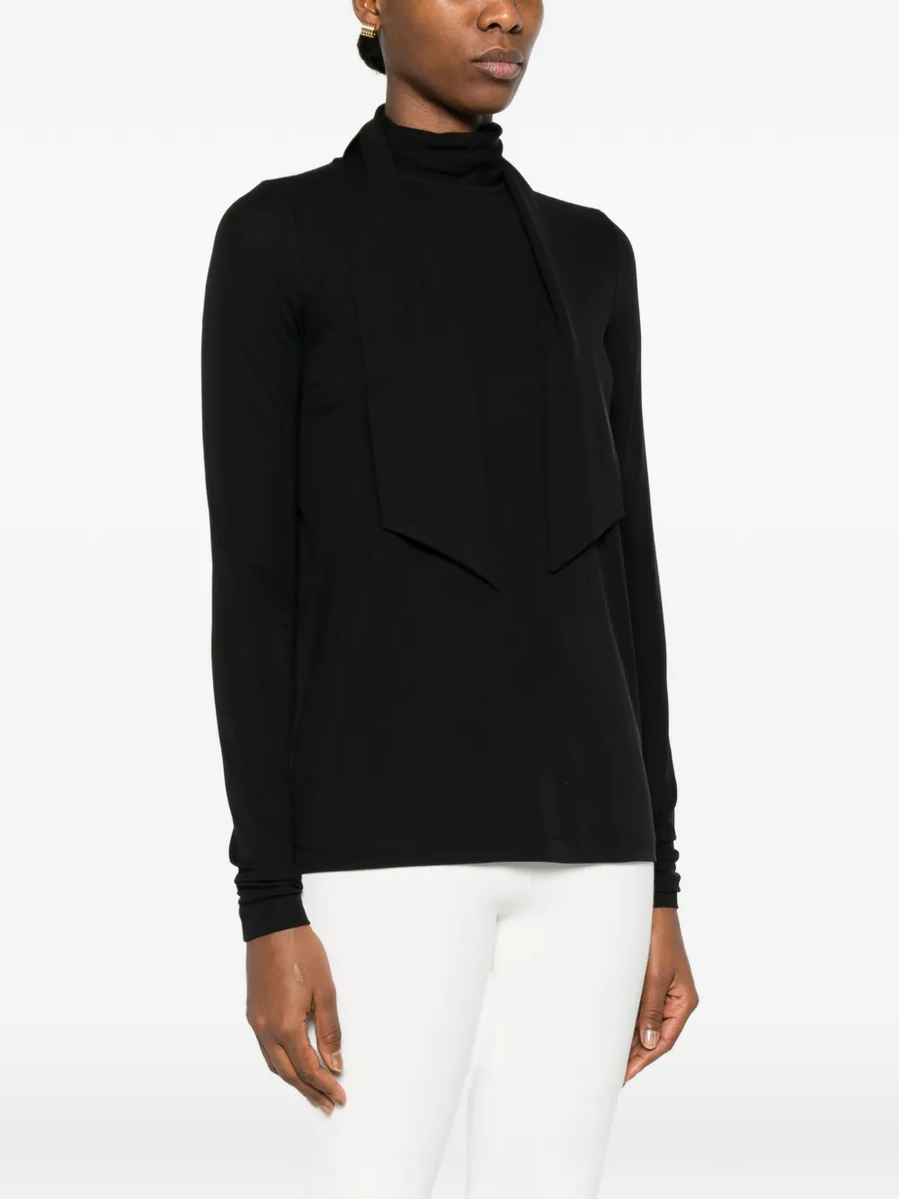 Black tops worn by a person, showing the tops' fit