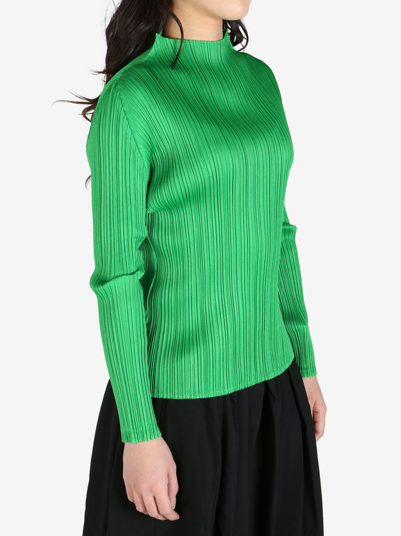 Green top worn by a person, side view