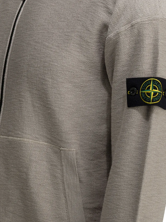 Gray sweatshirt with a brand logo on the sleeve