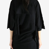 Black top worn by a person, showing the top's fit