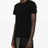 Black t-shirts worn by a person, showing the t-shirts fit