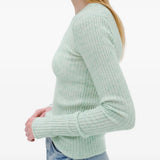 Green knitwear worn by a person, showing the knitwear fit