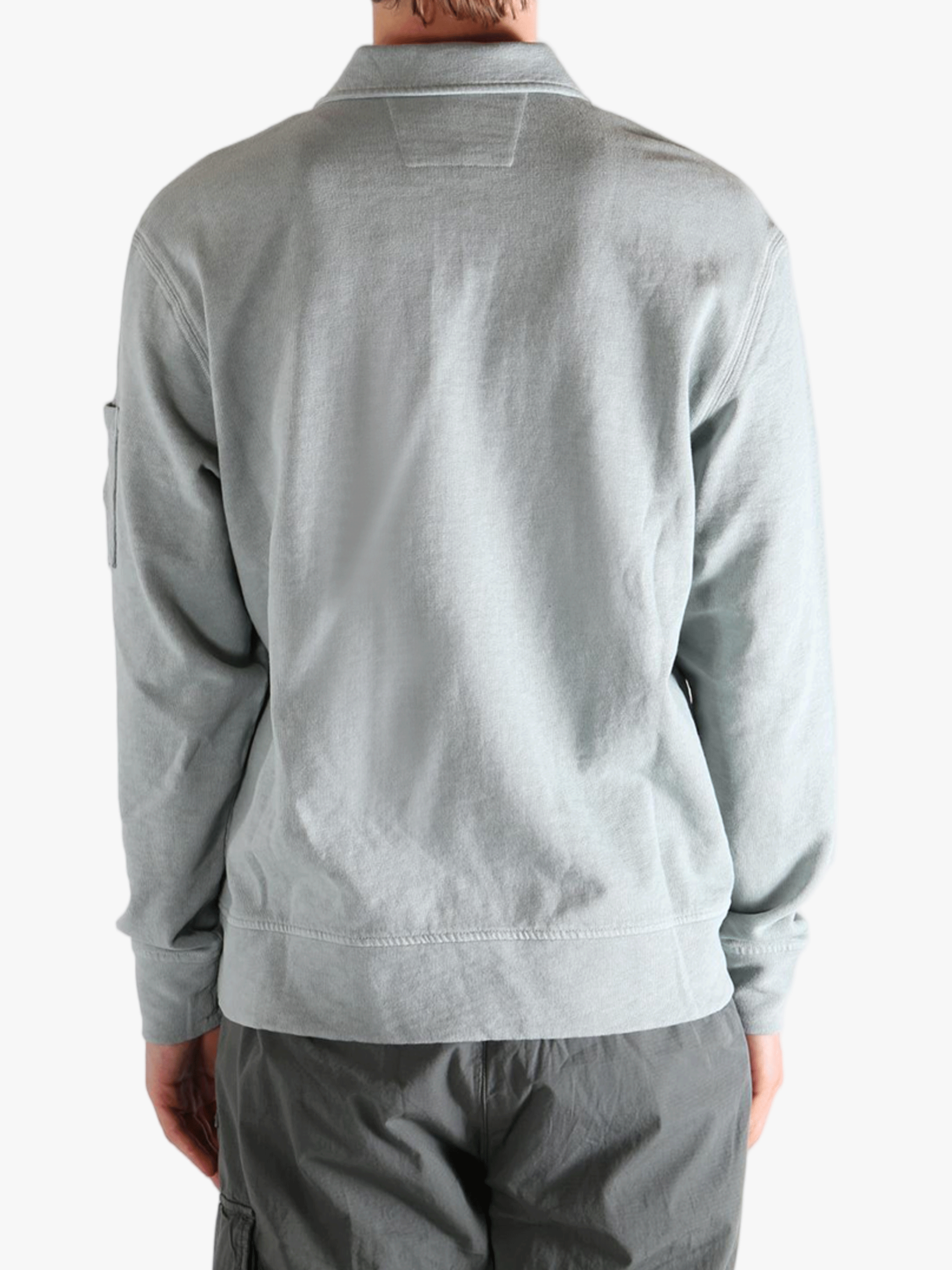 Gray long-sleeve shirt worn by a person, showing the shirt's fit