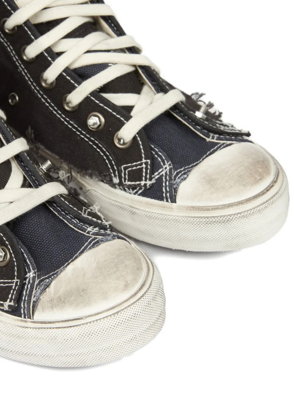 Close up of black sneakers, showing texture of the cotton and rubber and goat leather fabric