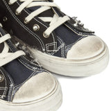 Close up of black sneakers, showing texture of the cotton and rubber and goat leather fabric