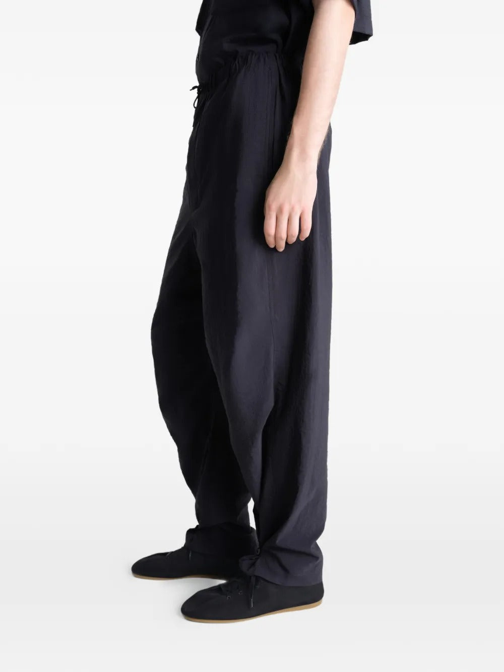 Black pants worn by a person, showing the pants' fit