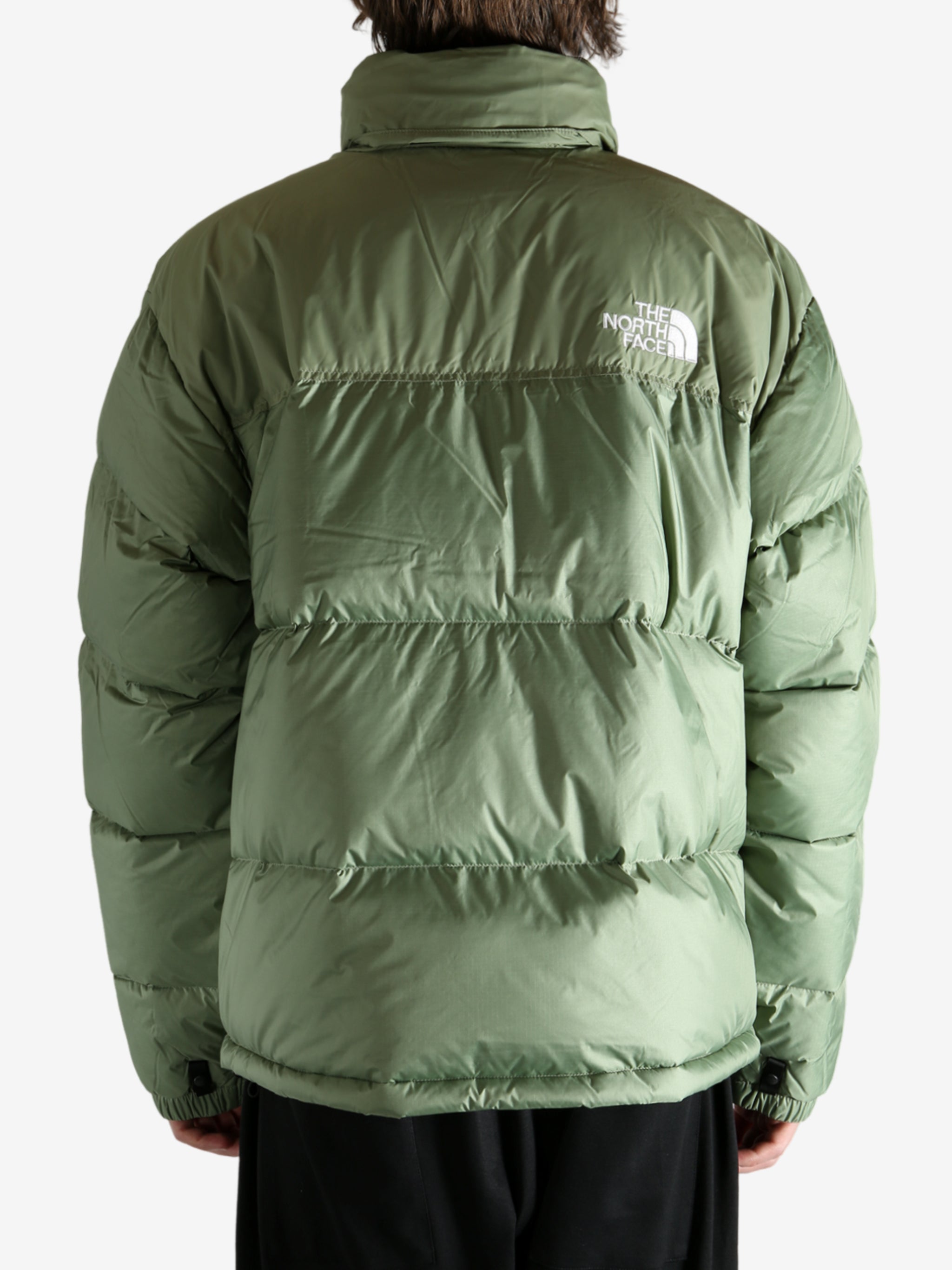 Green jacket worn by a person, showing the jacket's fit