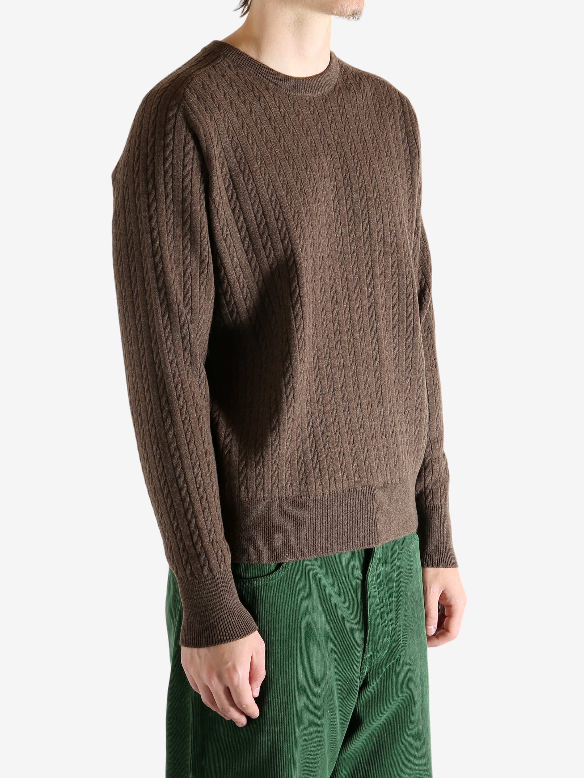Brown knitwear worn by a person, showing the knitwear's fit
