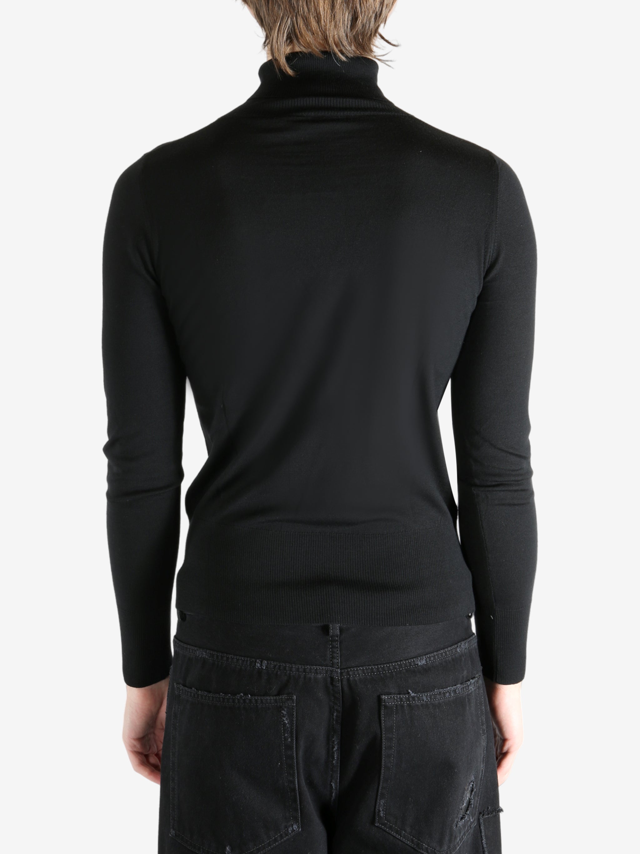 Black sweater worn by a person, showing the sweater's fit