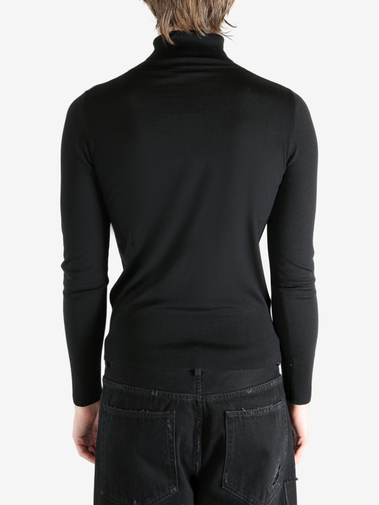 Black sweater worn by a person, showing the sweater's fit
